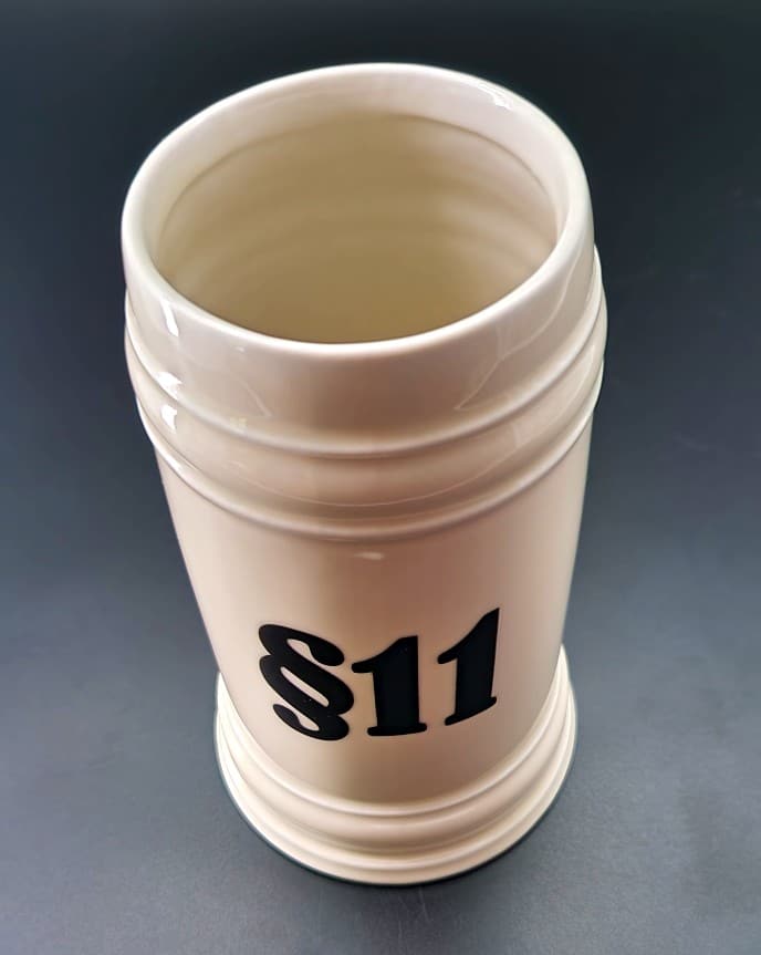 1 Liter Bierkrug aus Porzellan mit Aufschrift §11 Ansicht schräg oben