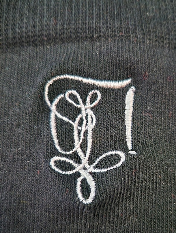 1 schwarze Socke mit Nahaufnahme Zirkel-Stickerei