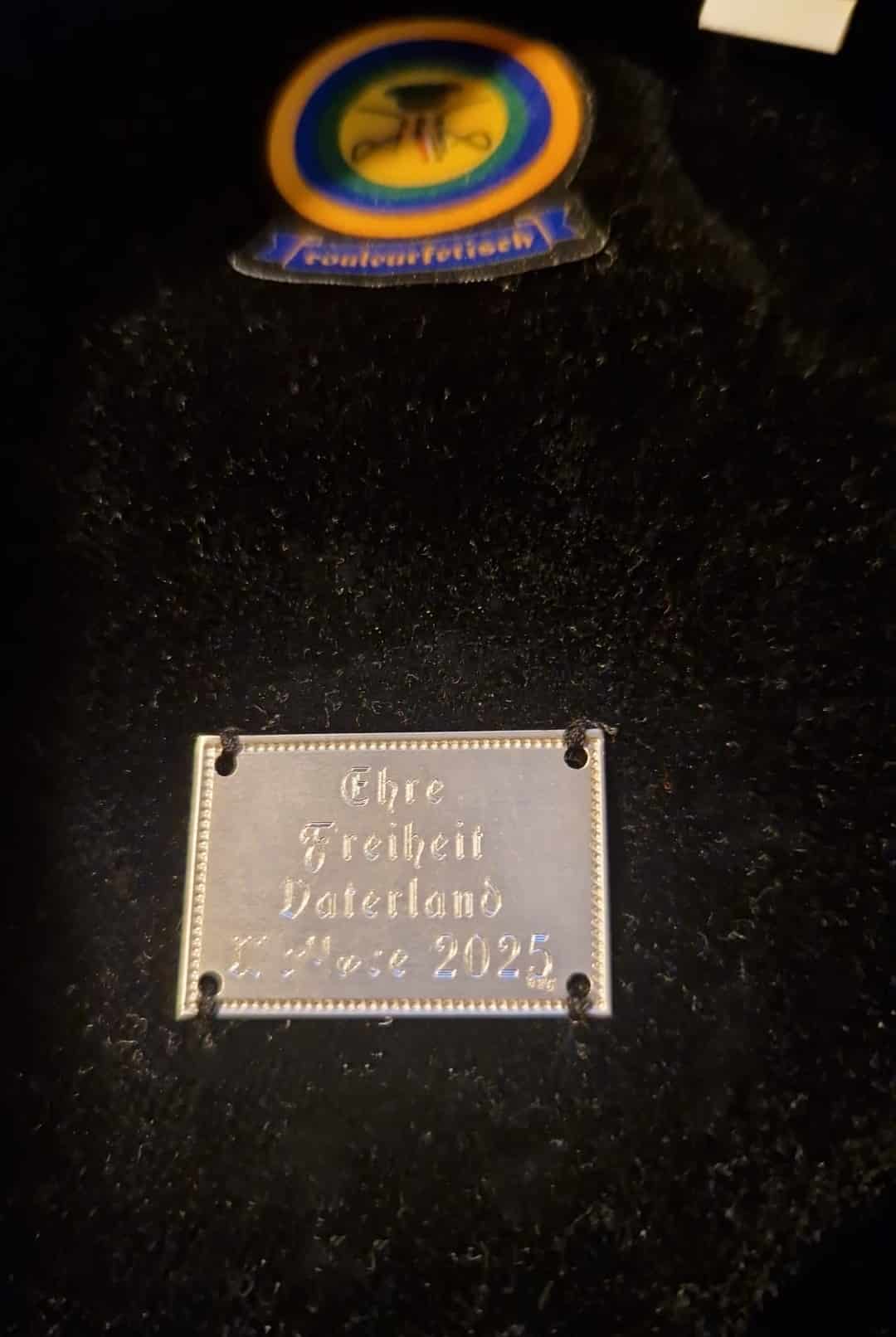 Nahaufnahme eines angenähten gravierten Widmungsschildchen